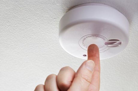 A man conducts smoke alarm maintenance in his Everett home.