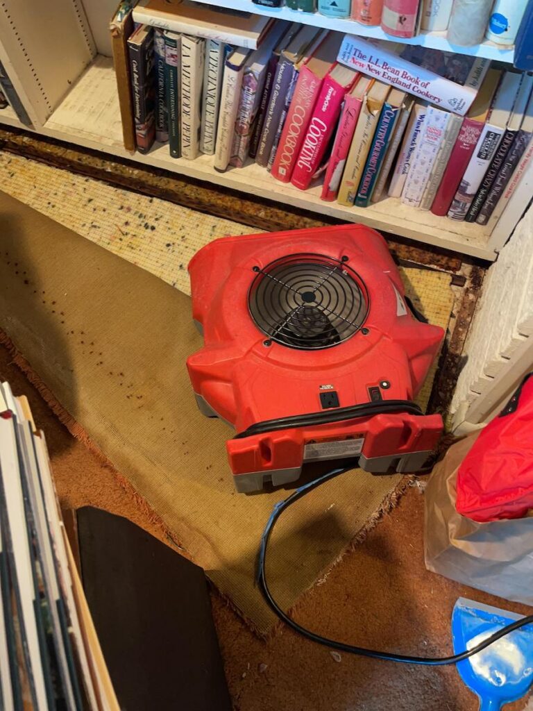 HEPA filters at work drying out water damage in a cluttered home