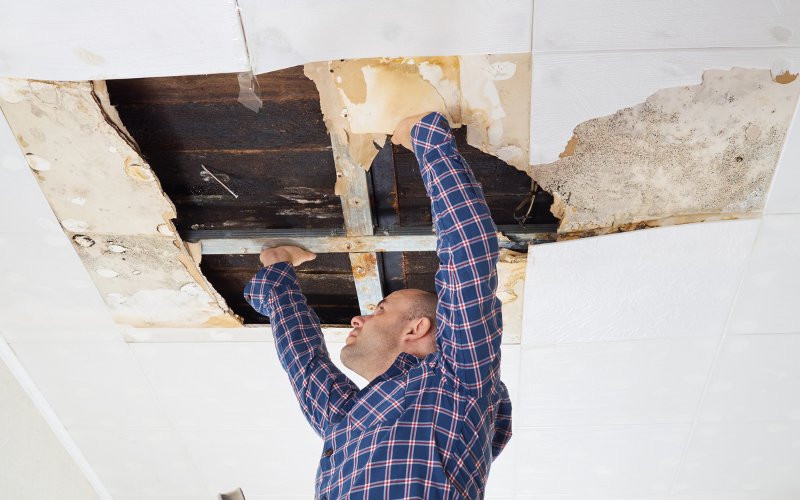 man-fixing-water-damamged-ceiling