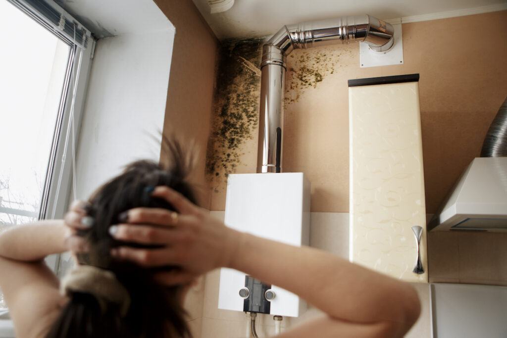 a woman finding mold while she's cleaning