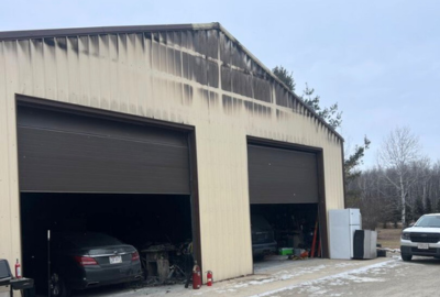 Structural fire damage on a commercial garage in Green Bay, with visible soot stains above the large overhead doors.