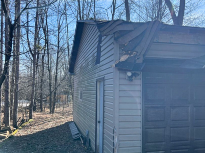 Damaged garage structure with visible roof and siding issues, highlighting the need for professional structural repair services in Green Bay.