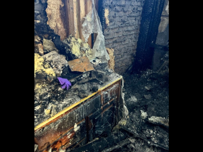 Severe fire and smoke damage to interior walls, insulation, and cabinets with charred debris, showing the need for professional smoke damage restoration.