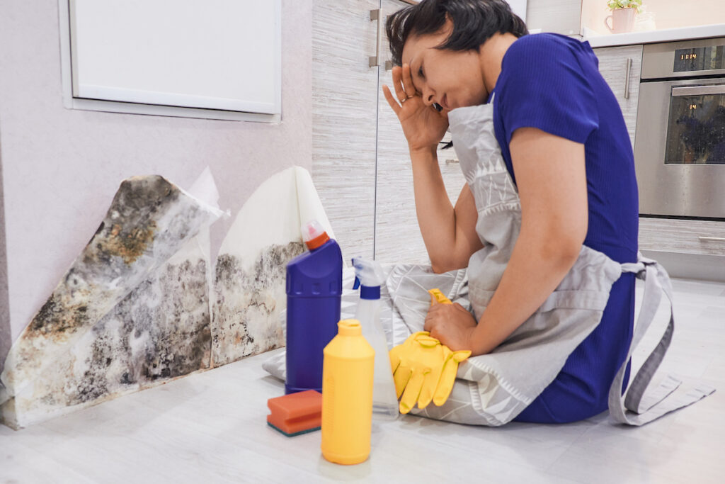a woman discovering mold in the middle of her spring cleaning
