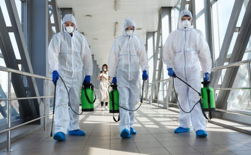 technician in protective gear preparing biohazard cleanup equipment