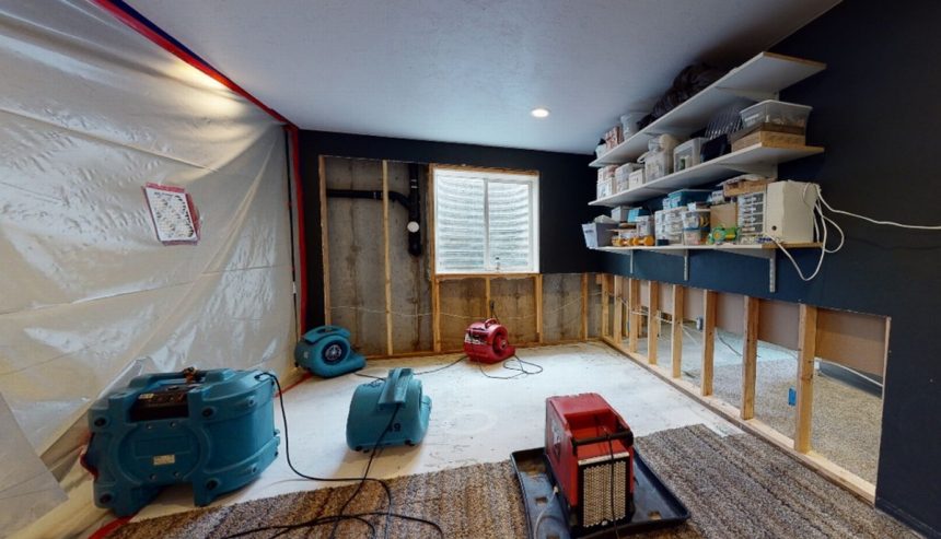 Interior of a residential home with water extraction equipment operating across multiple rooms, showing hoses, vacuums, and floor drying mats