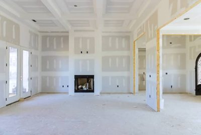contractor installing new clean drywall in a room after water mitigation