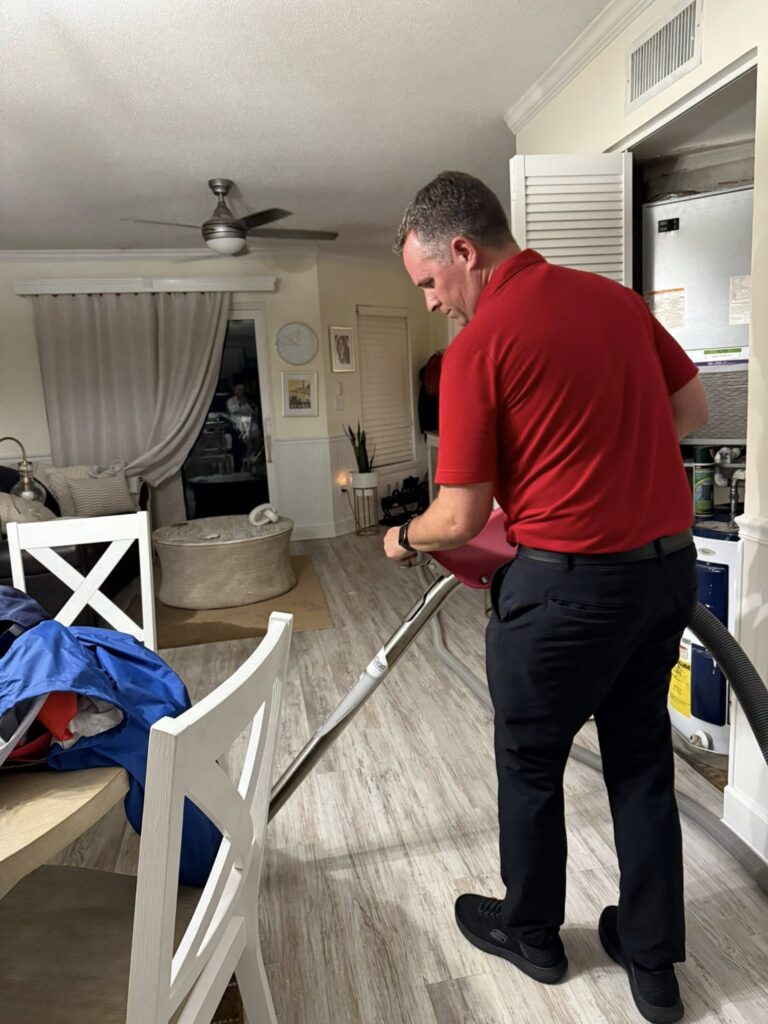 A PuroClean technician uses a extraction ward in a living room, demonstrating property restoration services.