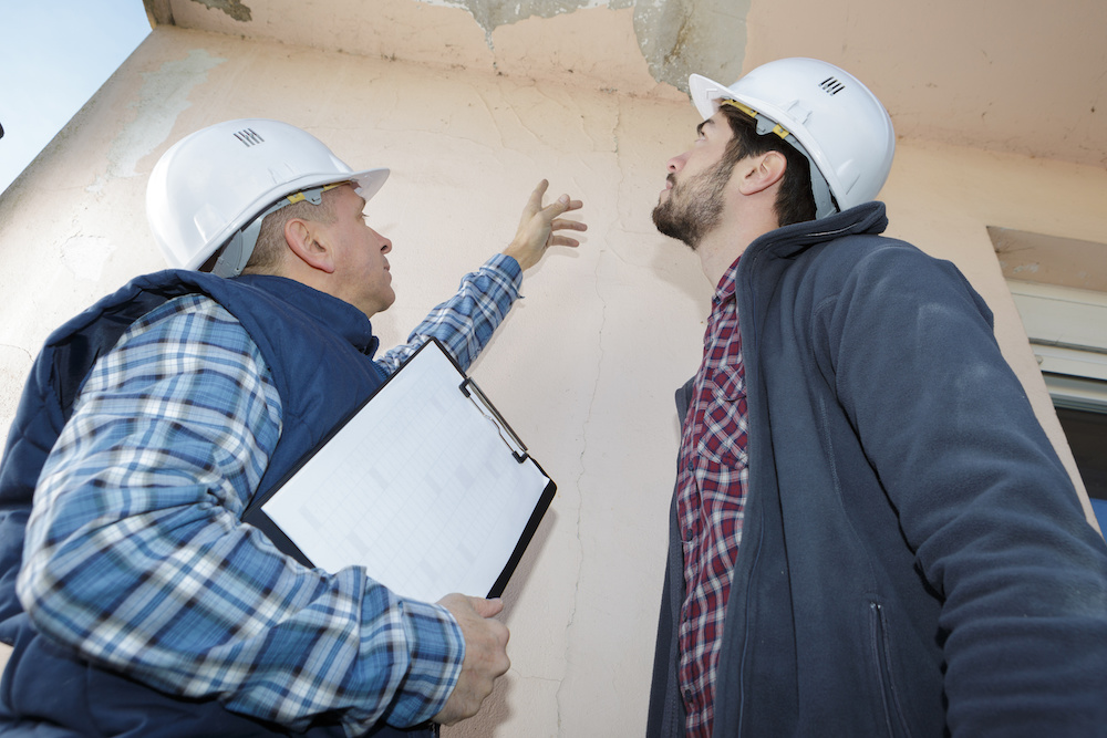 Professionals inspecting a leaky roof