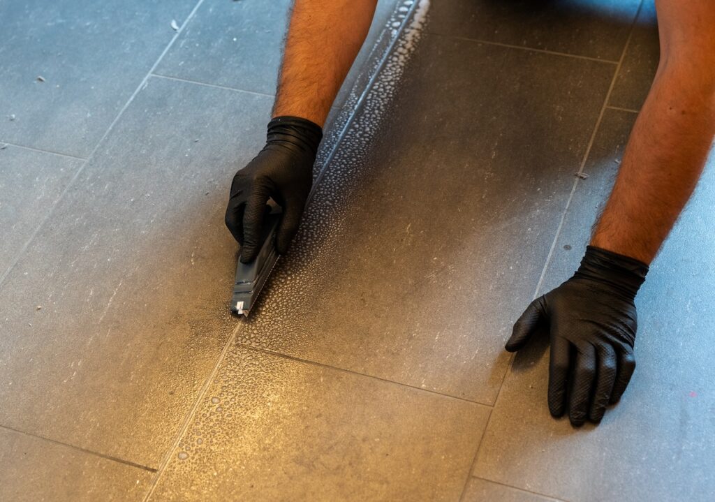 Use a soapy solution to carefully scrub your grout. 