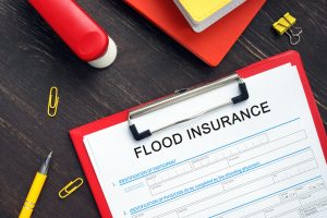 A clipboard holding a flood insurance policy