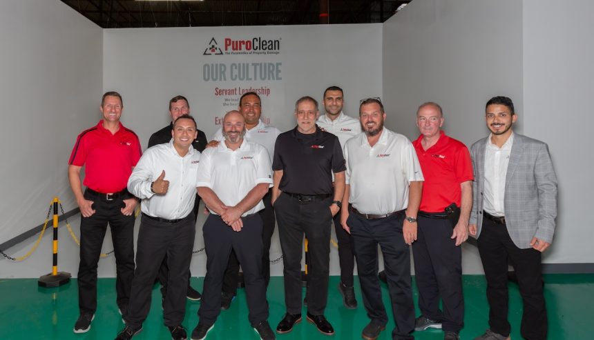PuroClean Commercial Sales Class attendees posing in front of a company backdrop.