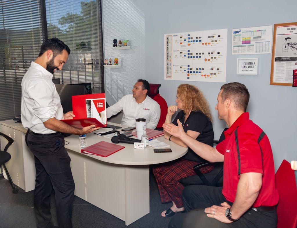 Franchisee owner Nilo Quiroz discusses property restoration services with fellow PuroClean technicians.