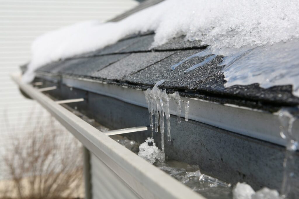 water built up in a gutter on the roof causing an ice dam. which can lead to roof damage and leaks.