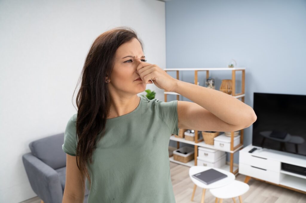 Woman Covering Her Nose From Bad Smell Inside The House of a rentalIf you notice a musty odor in your rental, investigate further.