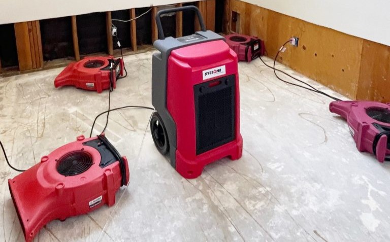 Air movers in dehumidifiers removing moisture content from structure and the surrounding air
