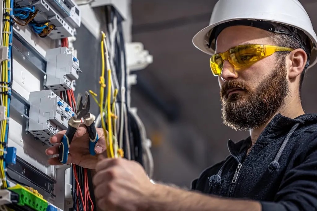 Electrician working on circuit breakers in a home in long island