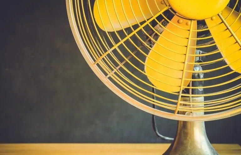 yellow fan that helps home owners stay cool in the summer heat