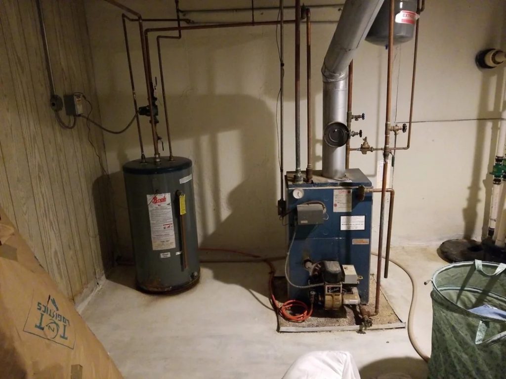 Furnace and water heater in a Long Island basement, requiring maintenance before winter.