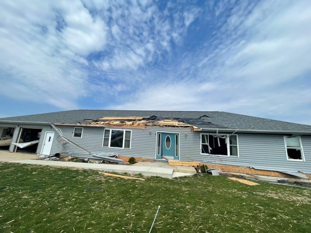 Tornado damage on the home's roof and garage.