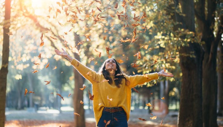 A woman enjoying the fall leaves
