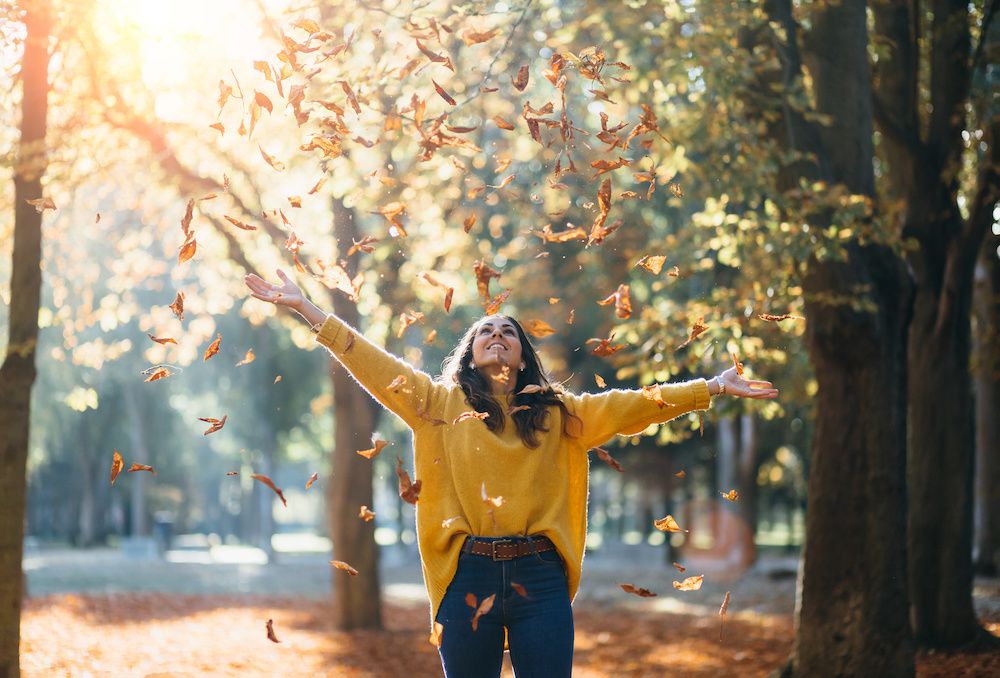 A woman enjoying the fall leaves