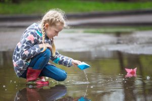 summer rain water damage - a child playing with rainwater