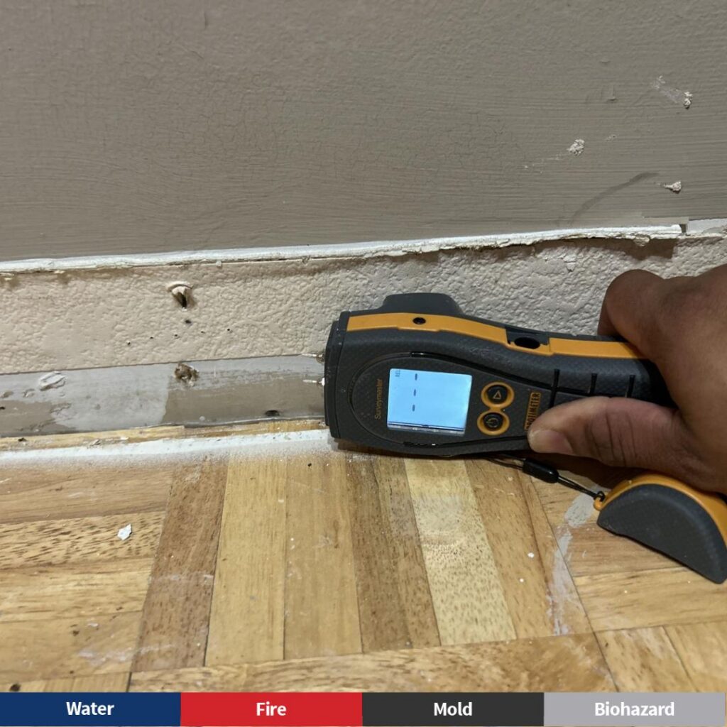 A moisture meter being used to find hidden water damage in Lawrenceville
