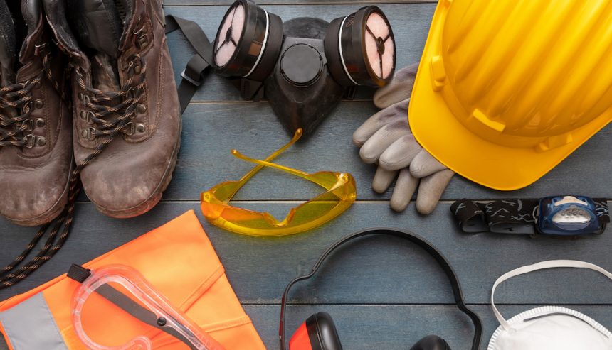Work safety protection equipment. A hard hat, googles, a ventilation mask, headphones, work light, and work boots.