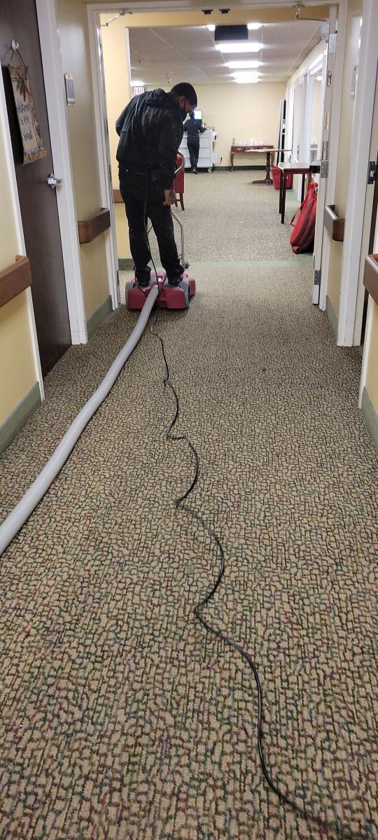 PuroClean technician using equipment to dry affected areas from burst pipe.