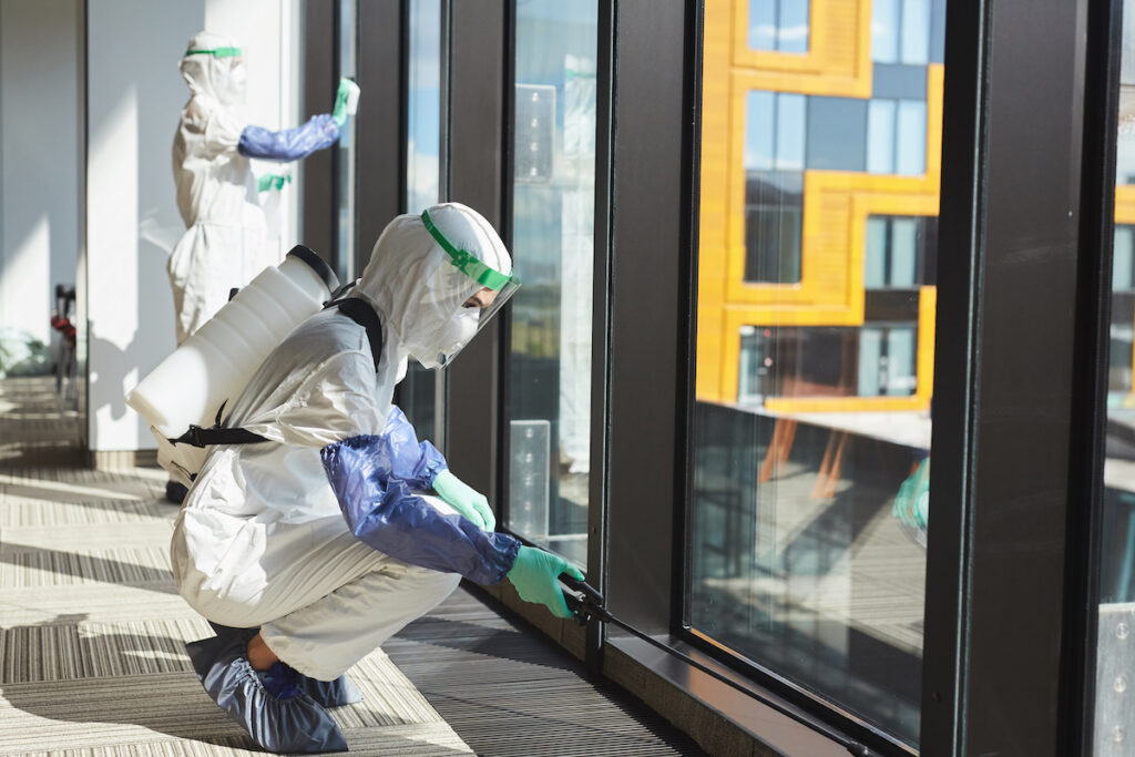 a technician works on a biohazard cleaning job, cleaning up a window