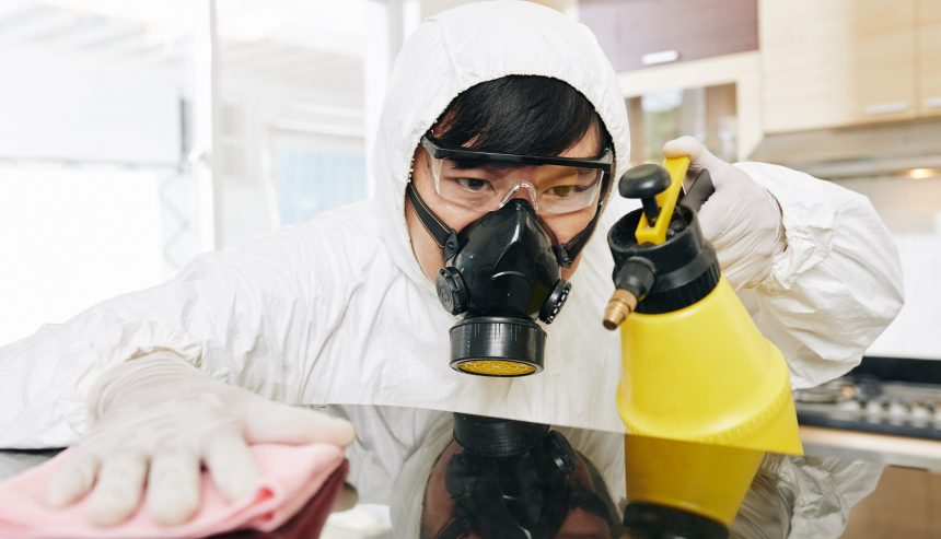 Technician cleaning kitchen counter for sanitization