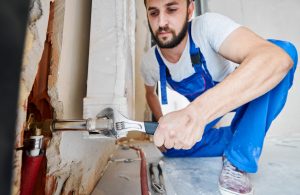 Plumber fixing plumbing fittings with a wrench