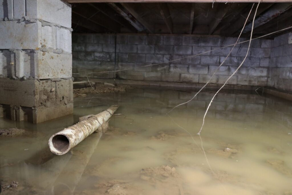 Flooded crawlspace with standing water under an older home