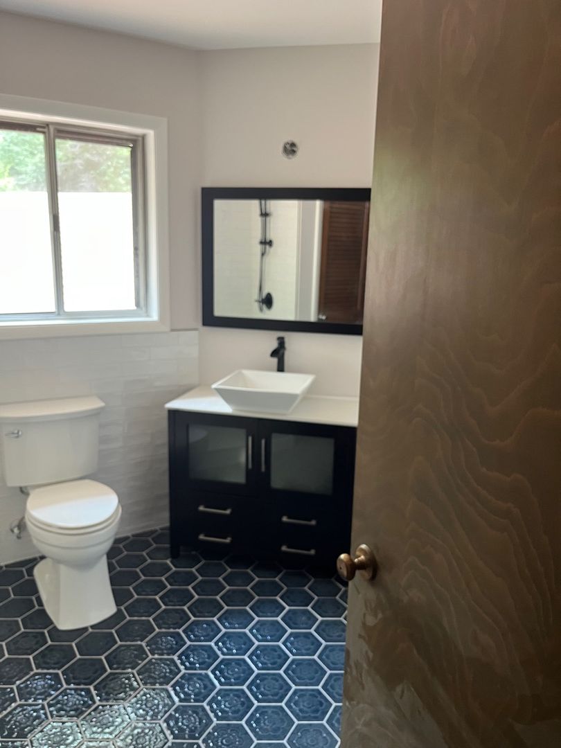 Restored Hapeville bathroom with new tile, vanity, mirror, and fixtures after PuroClean of East Cobb mold remediation