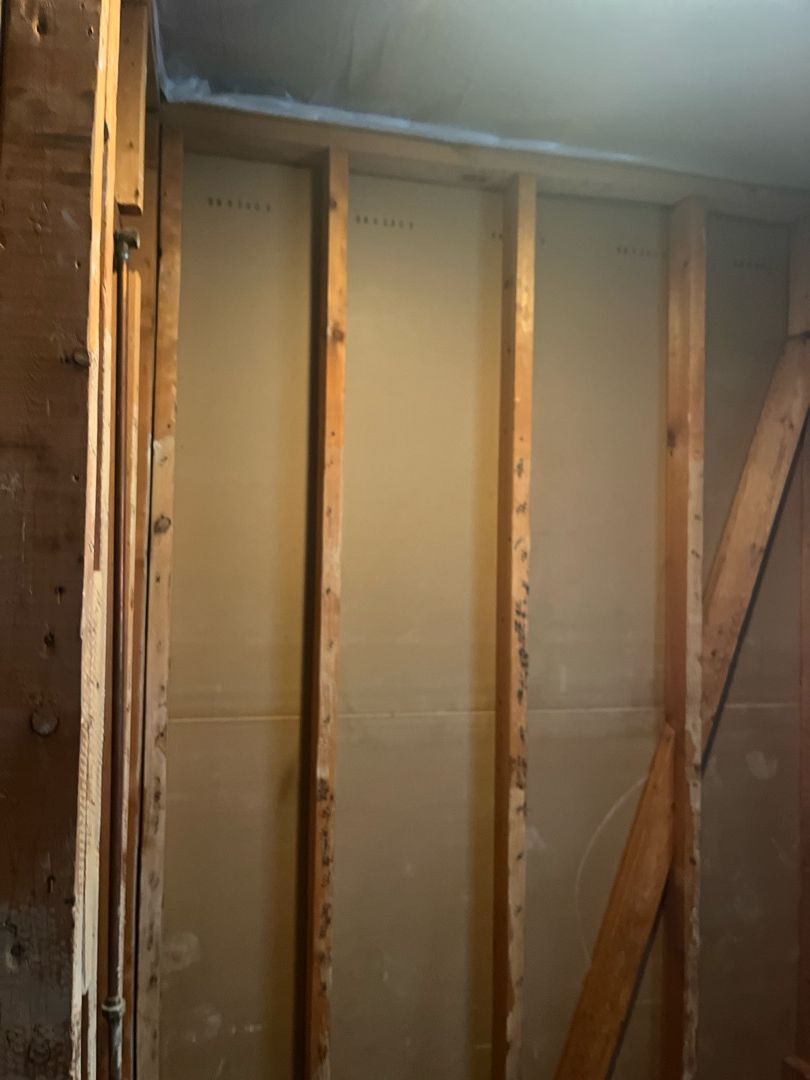 Mold-damaged bathroom wall with drywall removed down to the studs before PuroClean of East Cobb mold remediation in Hapeville