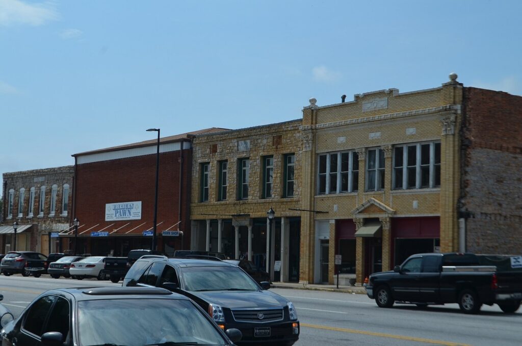 Historic stone and brick storefronts in the Fairburn Commercial Historic District on Broad Street, Fairburn, Georgia — the railroad-era town west of the Chattahoochee River