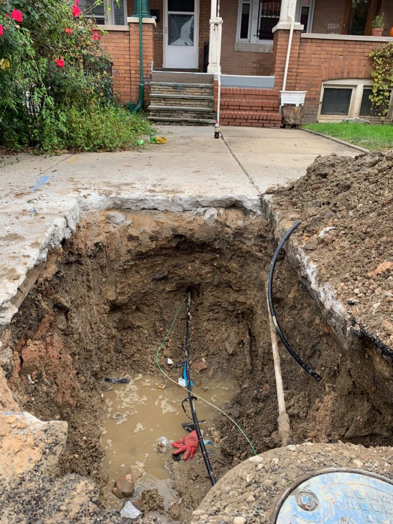 Excavated trench exposing a leaking underground residential water service line