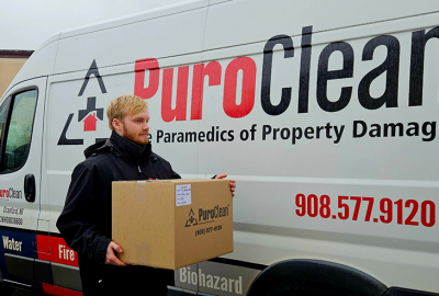 PuroClean team member carrying box for content doumentation and packout
