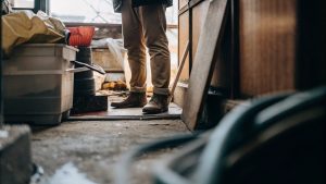 Worker standing in a cluttered room during hoarding cleanup.