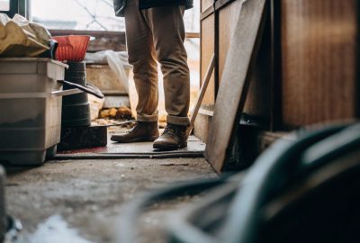 Worker standing in a cluttered room during hoarding cleanup.