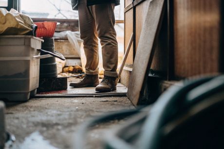 Worker standing in a cluttered room during hoarding cleanup.