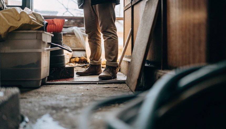 Worker standing in a cluttered room during hoarding cleanup.
