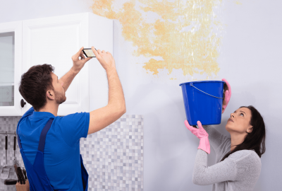 Homeowners checking ceiling water damage before professional water damage restoration in McLean VA.