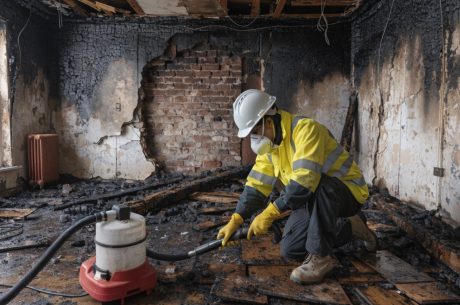 Professional technician performing fire damage cleanup in McLean VA, removing soot and debris during the fire restoration timeline process
