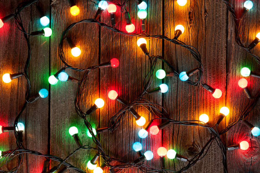 Christmas colorful lights on wooden table. holiday decoration safety tips