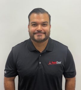 Smiling man with a beard wearing a black PuroClean polo shirt