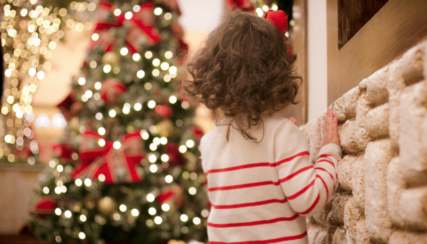 little girl looking at a Christmas tree