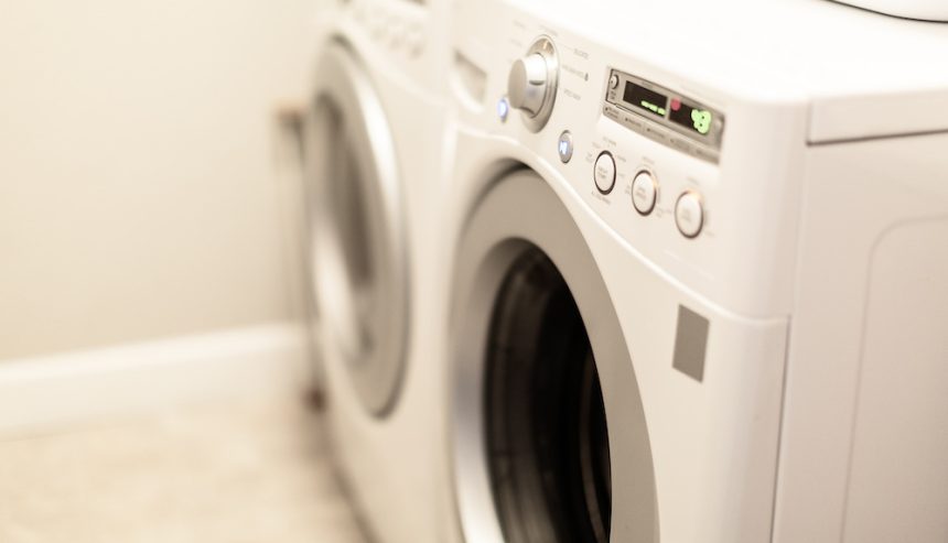 A close-up of a modern washing machine and dryer in a laundry room setting.