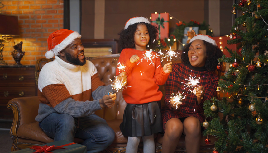 a family with sparklers and a lit Christmas tree: fire safety for kids